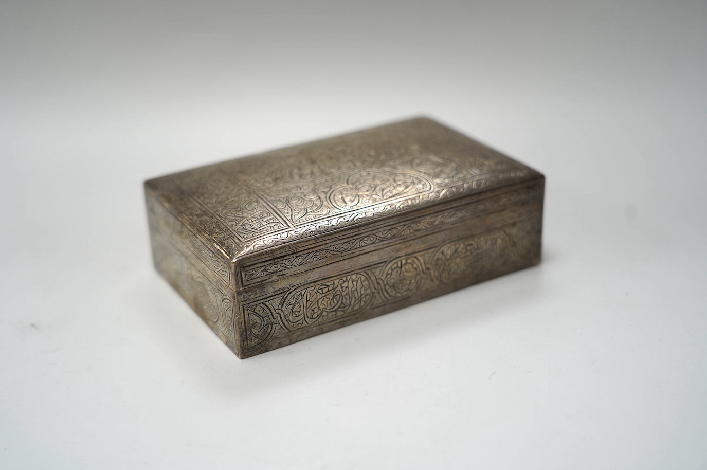 A Middle Eastern engraved white metal rectangular cigarette box, 12.5cm. Condition - fair